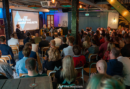 a group of people in a room with a screen