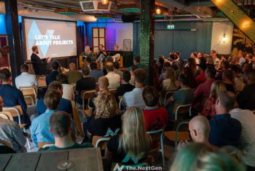 a group of people in a room with a screen